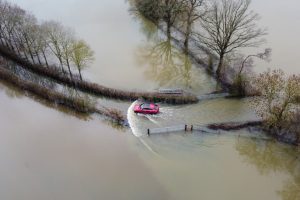 A stock photo of a car driving through a flood in England
